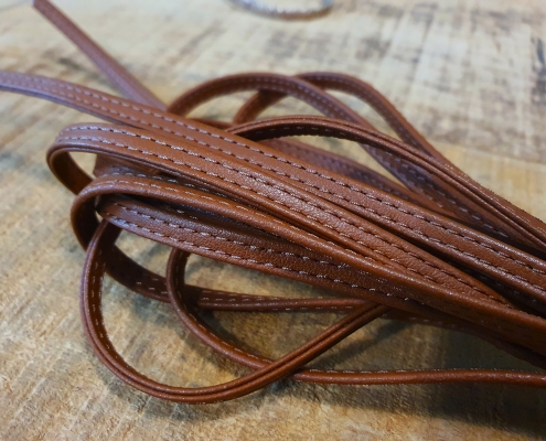 folded leather cord with stitching on sides for footwear